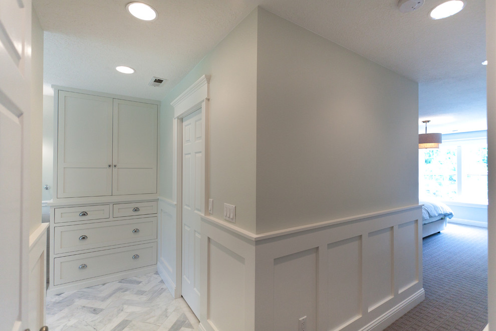 This is an example of a mid-sized transitional master bathroom in Portland with furniture-like cabinets, grey cabinets, marble benchtops, an undermount sink, a freestanding tub, a corner shower, a one-piece toilet, white tile, subway tile, white walls and marble floors.