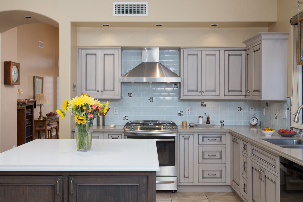 Example of a large transitional l-shaped ceramic tile open concept kitchen design in Phoenix with an undermount sink, beaded inset cabinets, gray cabinets, quartz countertops, white backsplash, glass tile backsplash, black appliances and an island