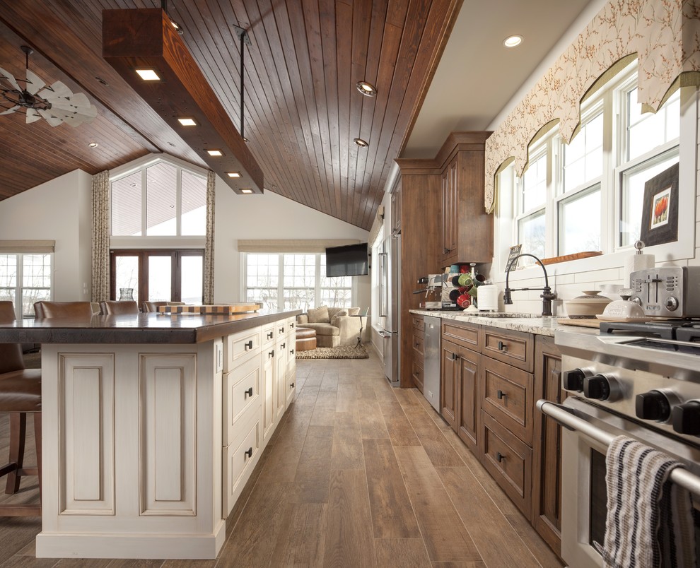 Inspiration for a rustic kitchen remodel with an undermount sink, recessed-panel cabinets, light wood cabinets, wood countertops, white backsplash, ceramic backsplash, stainless steel appliances and brown countertops