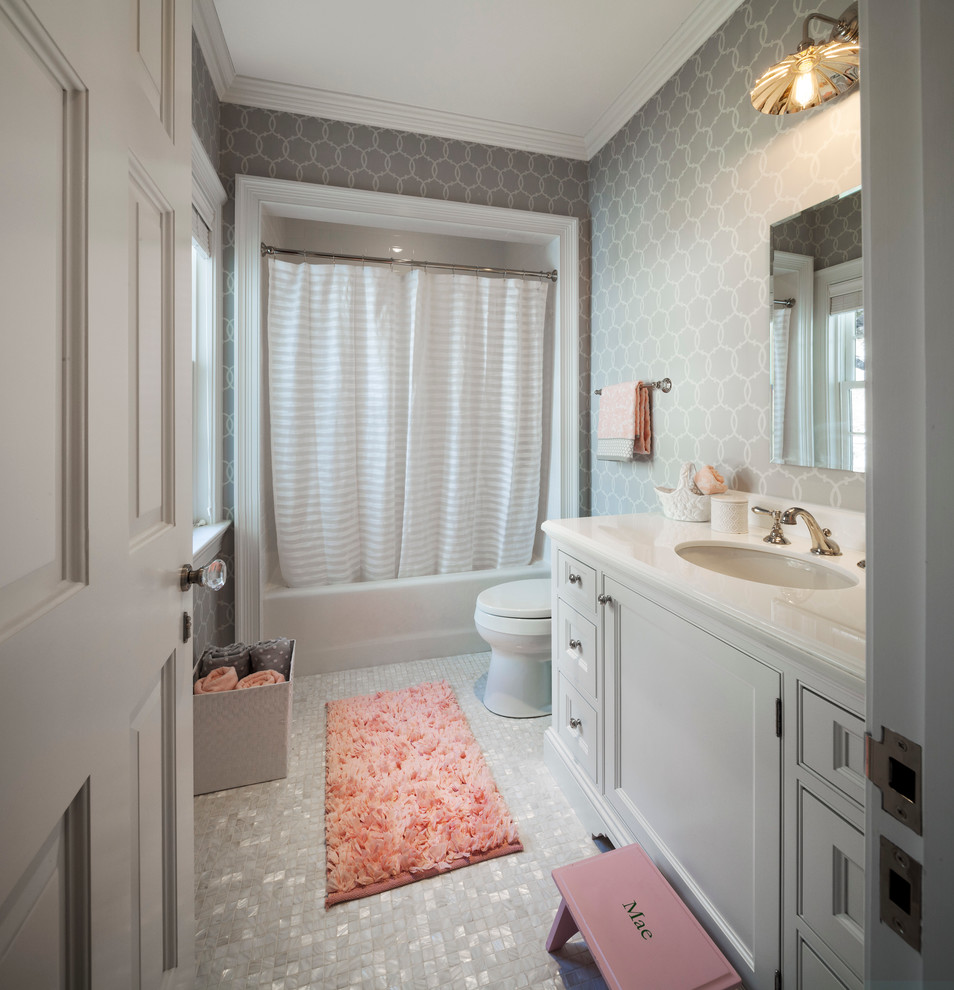 Photo of a mid-sized traditional kids bathroom in Other with recessed-panel cabinets, white cabinets, an alcove tub, a one-piece toilet, white tile, mosaic tile, grey walls, mosaic tile floors, an undermount sink and marble benchtops.