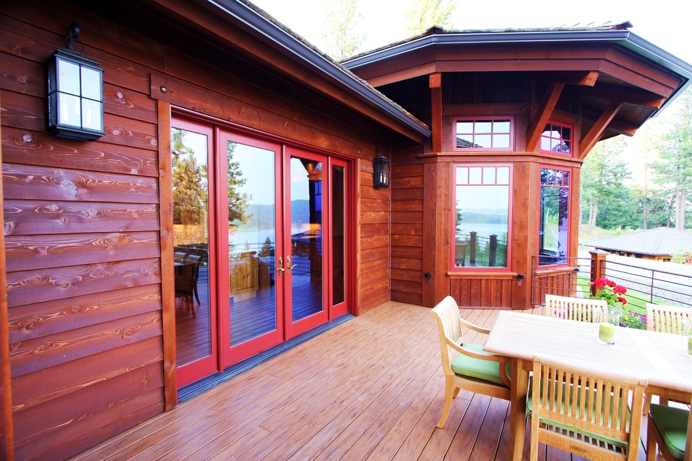 Photo of a large contemporary backyard deck in Seattle with a fire feature and a roof extension.