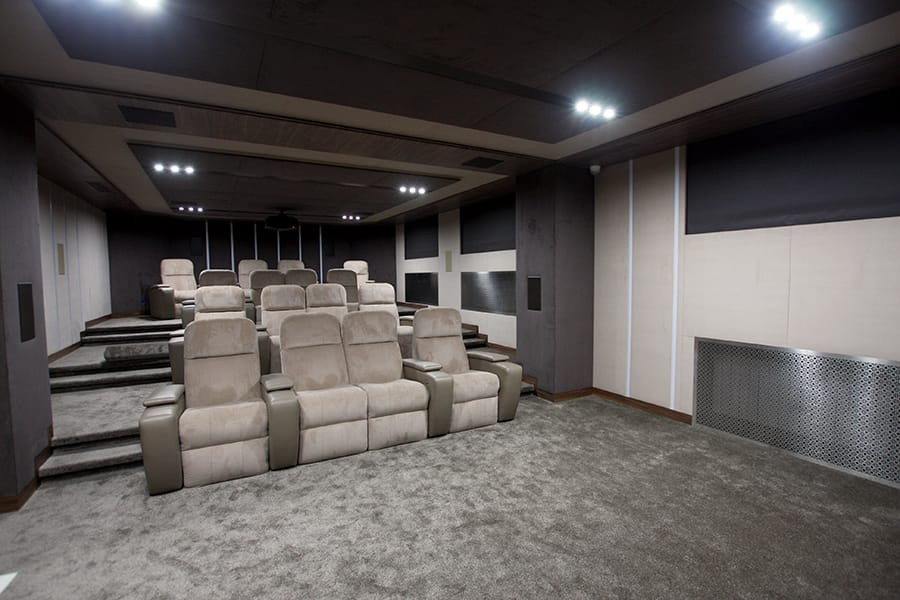 На фото: изолированный домашний кинотеатр в современном стиле с бежевыми стенами, ковровым покрытием, проектором и коричневым полом с