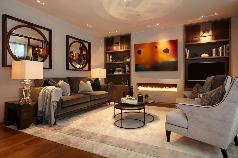 Mid-sized transitional living room in London with grey walls, a ribbon fireplace, a wall-mounted tv, brown floor and medium hardwood floors.