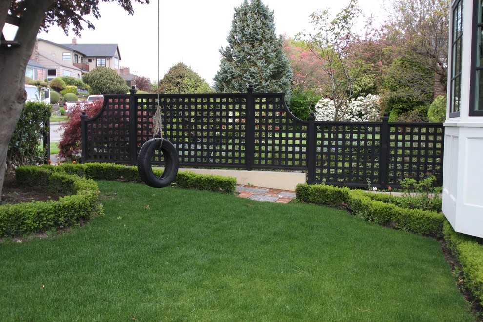 Photo of a large traditional front yard full sun driveway in Seattle with natural stone pavers and with a gate.