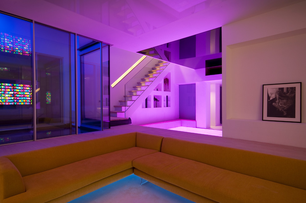 Large contemporary basement in London with white walls and light hardwood floors.