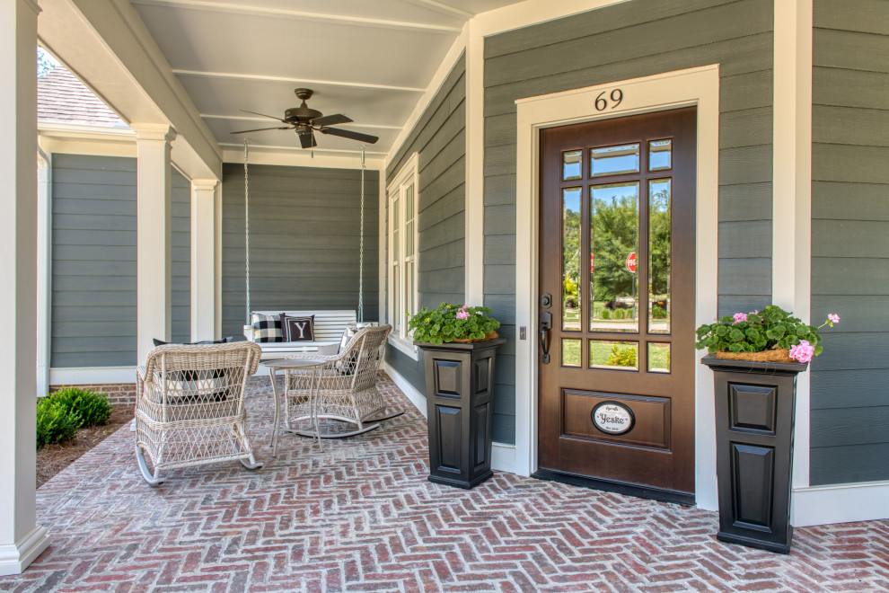 Photo of a medium sized traditional front veranda in Atlanta with with columns and brick paving.