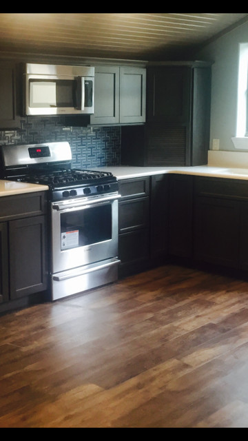 Example of a mid-sized transitional u-shaped light wood floor eat-in kitchen design in Austin with a double-bowl sink, raised-panel cabinets, black cabinets, soapstone countertops, white backsplash, mosaic tile backsplash, stainless steel appliances and no island
