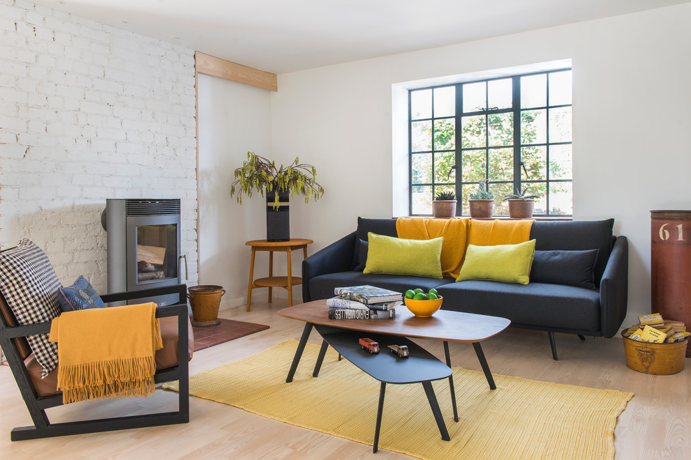 Design ideas for a medium sized scandi open plan living room with white walls, light hardwood flooring, a wood burning stove, a brick fireplace surround, beige floors and no tv.
