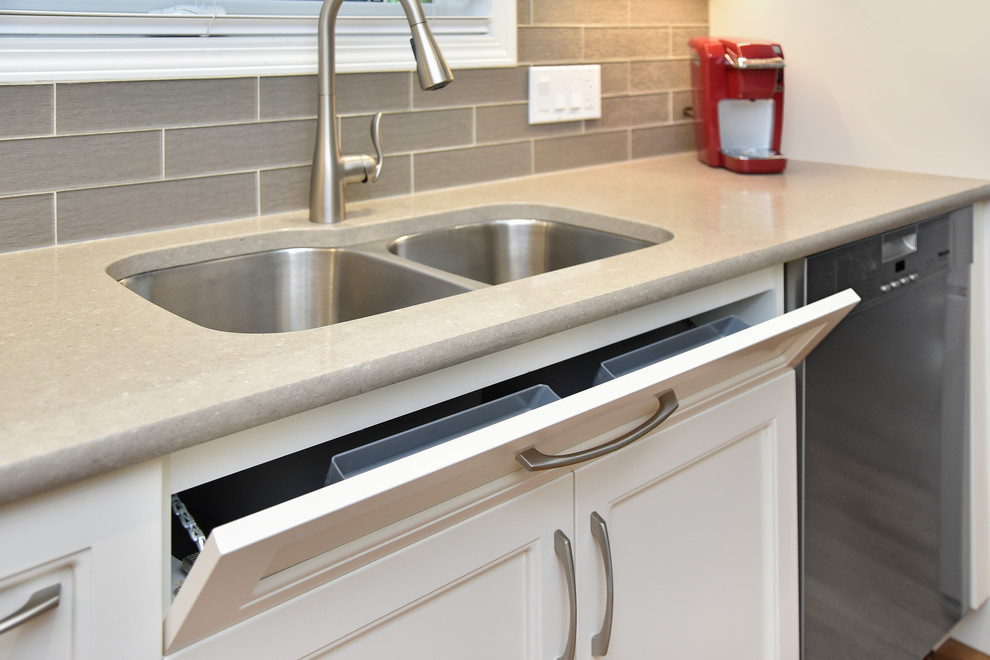 Eat-in kitchen - mid-sized transitional l-shaped medium tone wood floor and beige floor eat-in kitchen idea in Calgary with an undermount sink, recessed-panel cabinets, white cabinets, quartz countertops, gray backsplash, glass tile backsplash, stainless steel appliances and an island