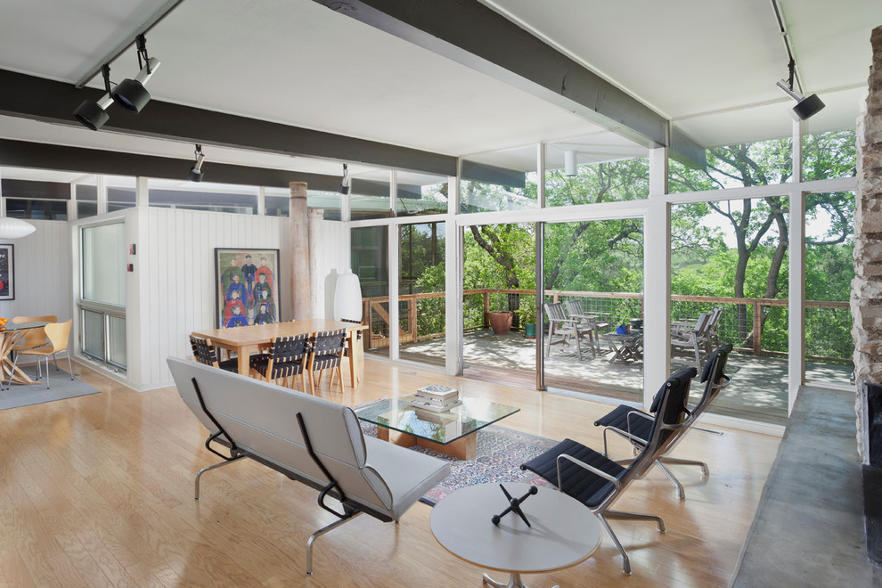 Inspiration for a mid-sized midcentury open concept living room in Austin with white walls and light hardwood floors.