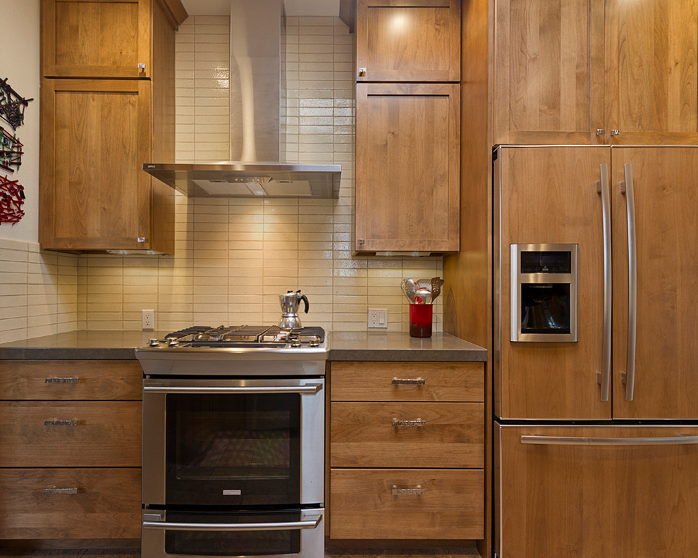 Example of a mid-sized transitional galley enclosed kitchen design in Phoenix with shaker cabinets, medium tone wood cabinets, quartz countertops, white backsplash, subway tile backsplash, stainless steel appliances and white walls