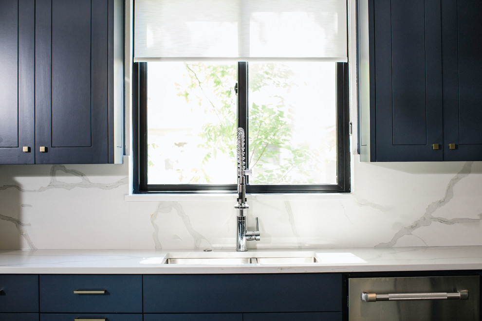 Example of a mid-sized transitional l-shaped cement tile floor and gray floor eat-in kitchen design in Austin with an undermount sink, flat-panel cabinets, blue cabinets, quartz countertops, white backsplash, stainless steel appliances, an island and white countertops