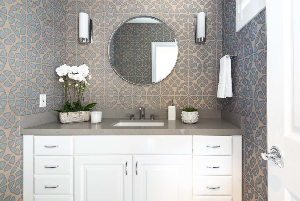 Photo of a small transitional powder room in Los Angeles with raised-panel cabinets, a one-piece toilet, blue tile, blue walls, ceramic floors, an undermount sink, engineered quartz benchtops, grey floor and grey benchtops.