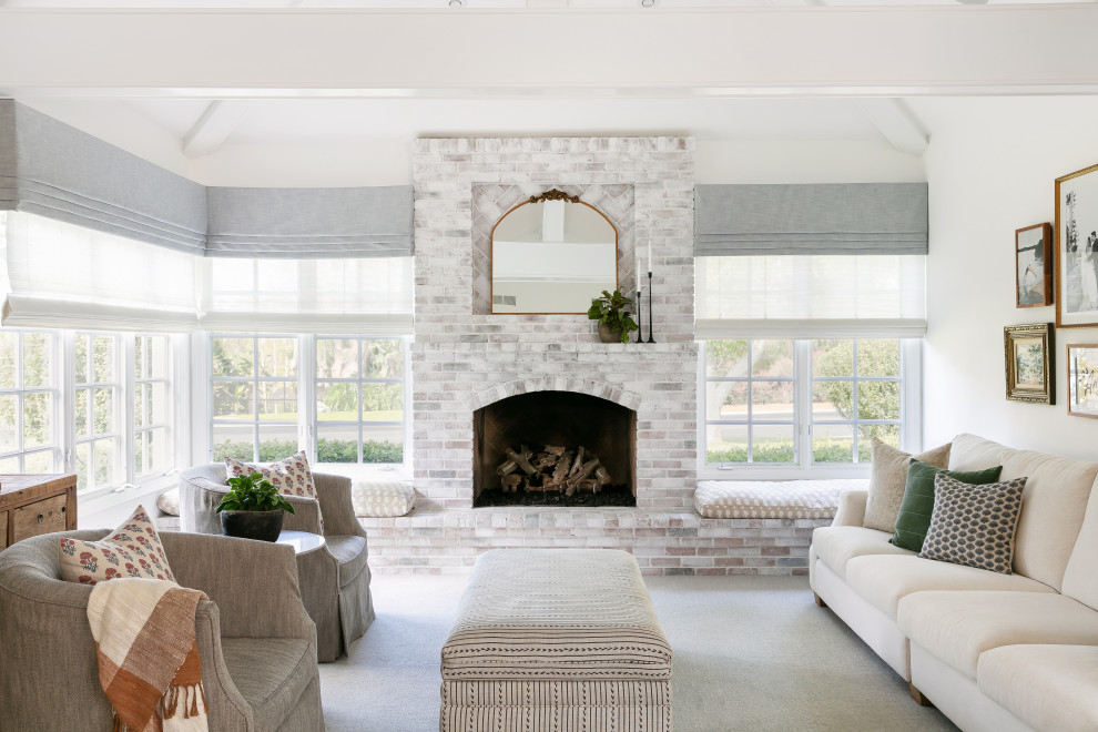 This is an example of a transitional living room in San Diego with a home bar, white walls, medium hardwood floors, a standard fireplace, a brick fireplace surround and exposed beam.