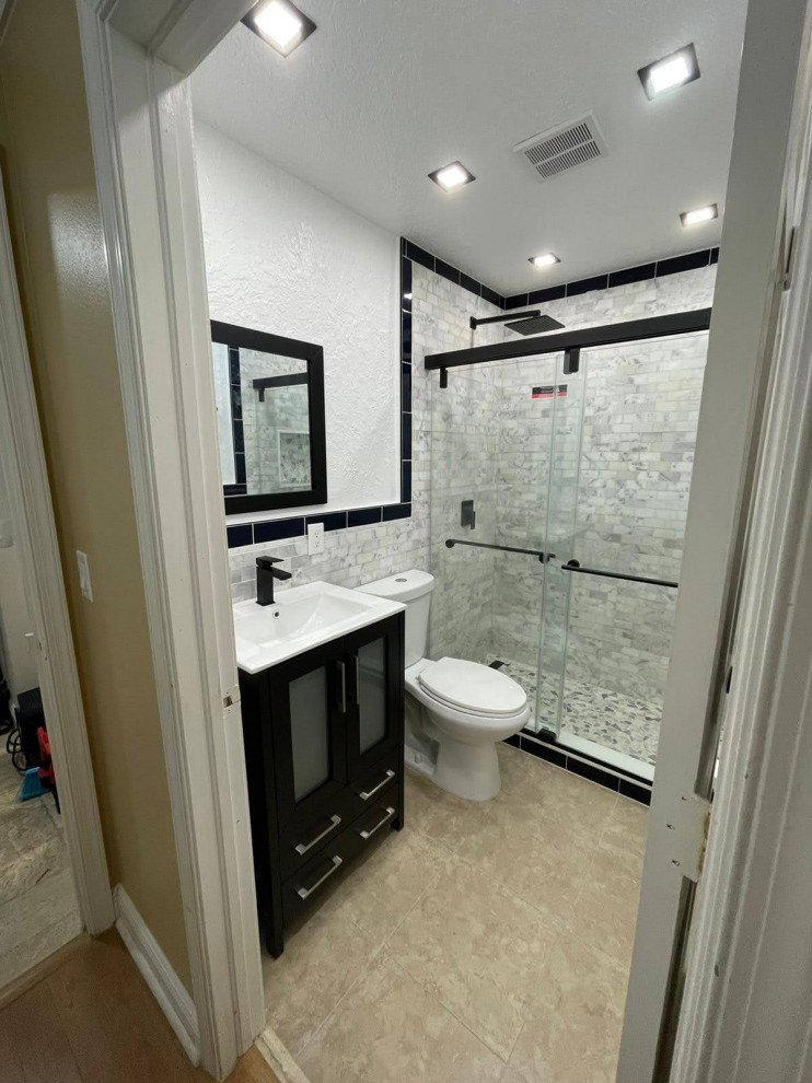 Свежая идея для дизайна: маленькая ванная комната в морском стиле с фасадами в стиле шейкер, черными фасадами, душем в нише, раздельным унитазом, белой плиткой, мраморной плиткой, белыми стенами, мраморным полом, монолитной раковиной, столешницей из искусственного кварца, бежевым полом, душем с раздвижными дверями, белой столешницей, нишей, тумбой под одну раковину и напольной тумбой для на участке и в саду - отличное фото интерьера