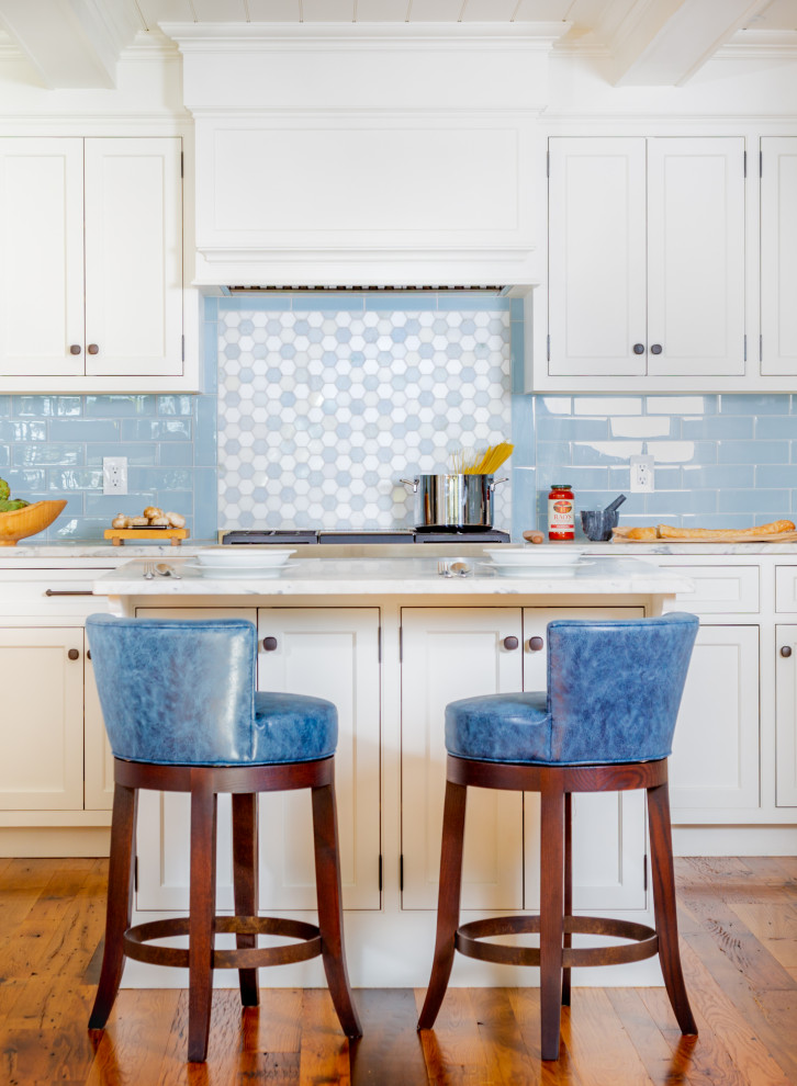 Design ideas for a mid-sized beach style kitchen in Boston with white cabinets, marble benchtops, blue splashback, mosaic tile splashback, medium hardwood floors, with island, brown floor, white benchtop and timber.