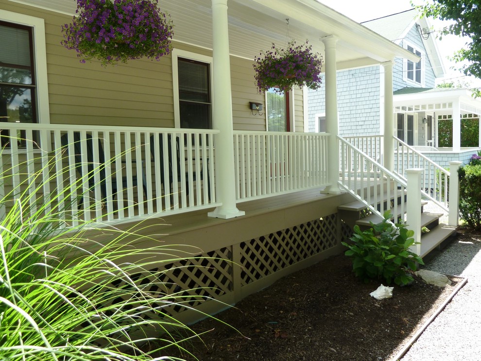 Beach style front yard verandah in Providence with a roof extension.
