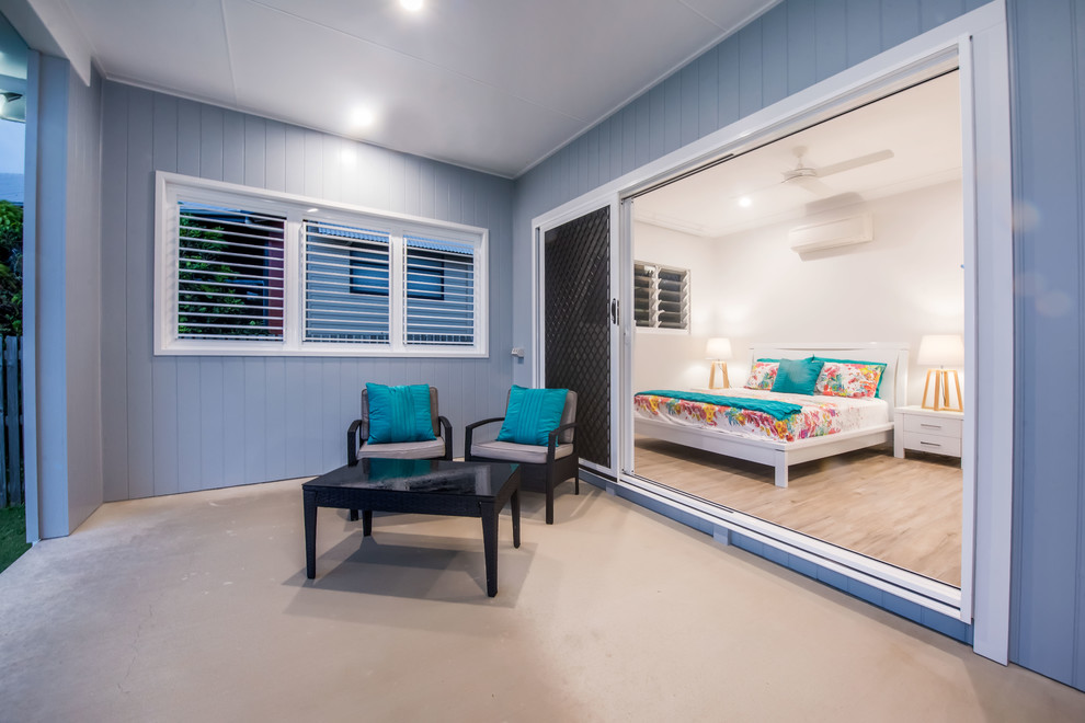 Mid-sized beach style backyard patio in Other with concrete slab and a roof extension.