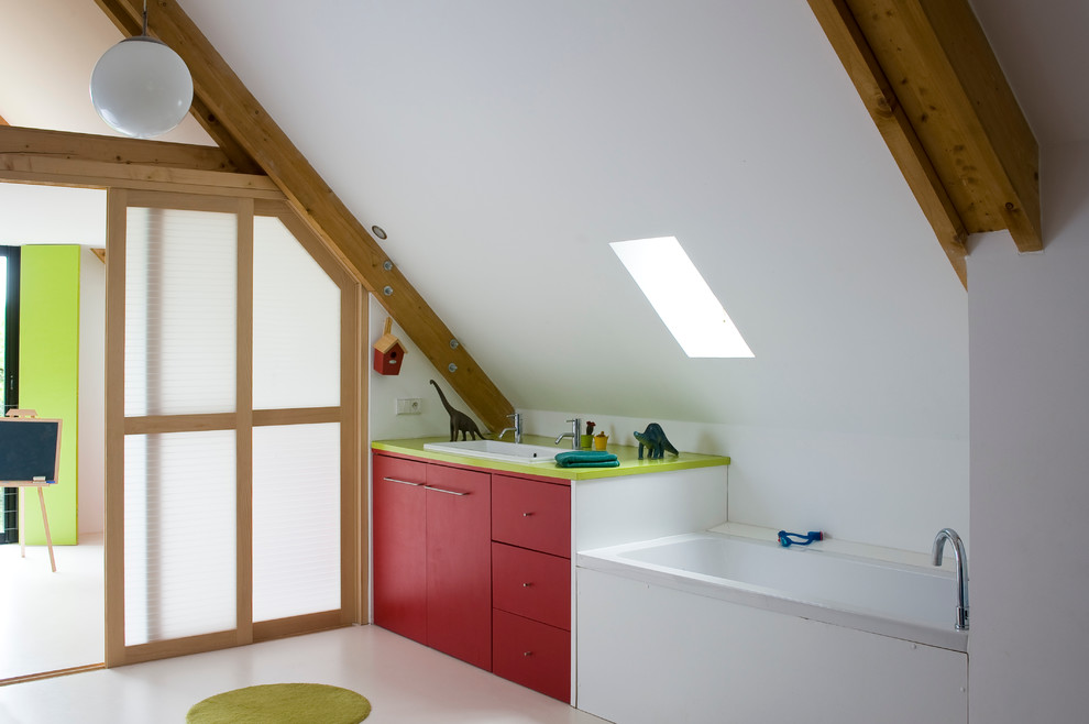 Inspiration for a mid-sized contemporary kids bathroom in Paris with a drop-in sink, flat-panel cabinets, red cabinets, a drop-in tub and white walls.