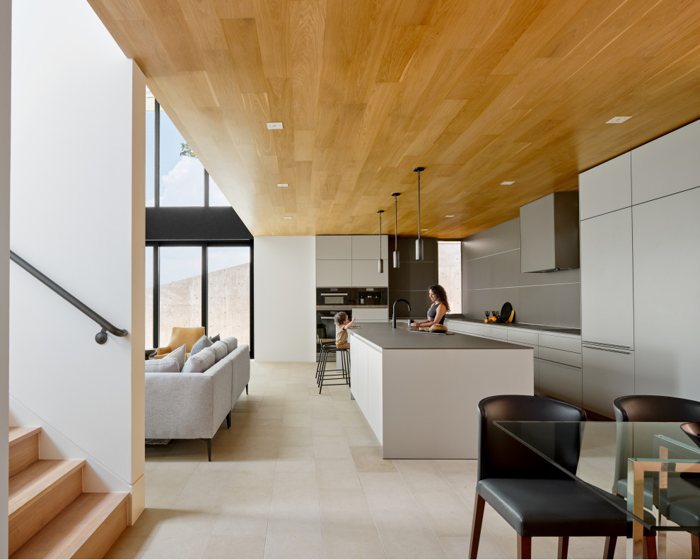 Esempio di una grande cucina moderna con lavello sottopiano, ante lisce, ante grigie, paraspruzzi grigio, pavimento in pietra calcarea, pavimento beige e soffitto in legno