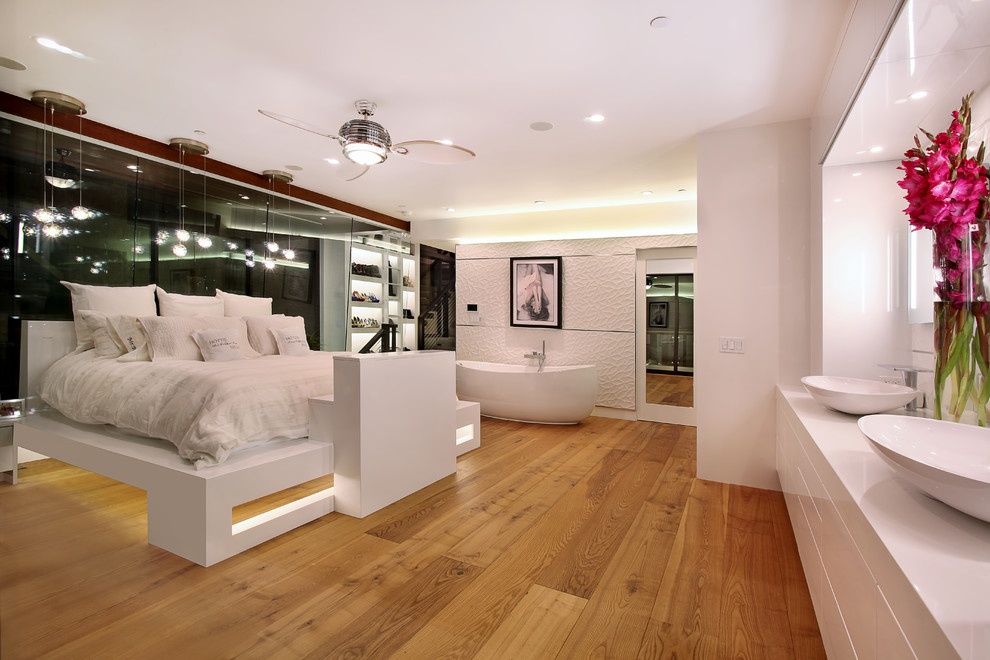 Design ideas for a contemporary bedroom in Orange County with white walls and medium hardwood floors.