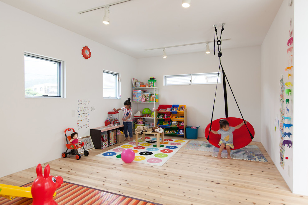 Design ideas for a scandinavian gender-neutral kids' playroom for kids 4-10 years old in Other with white walls and light hardwood floors.