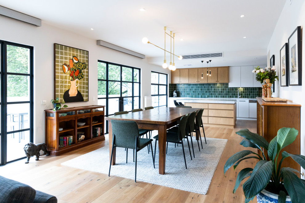 Photo of a mid-sized contemporary open plan dining in Melbourne with white walls, medium hardwood floors and no fireplace.