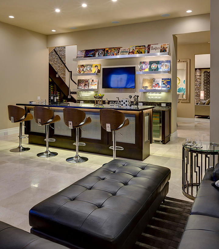 This is an example of an expansive contemporary open concept home theatre in Orlando with beige walls, travertine floors and a wall-mounted tv.