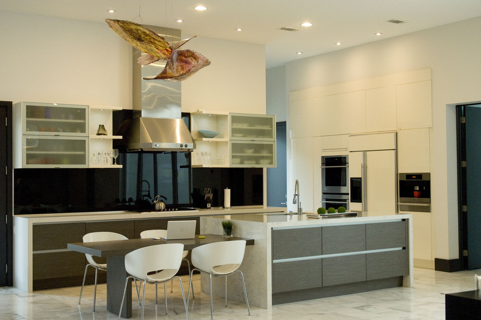 Photo of a large contemporary l-shaped separate kitchen in New Orleans with an undermount sink, flat-panel cabinets, white cabinets, quartz benchtops, black splashback, stone slab splashback, panelled appliances, marble floors, with island and white floor.