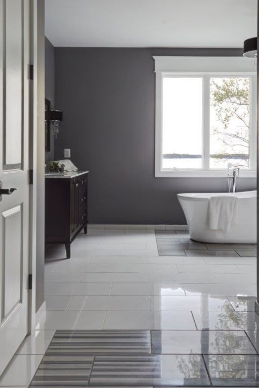 Photo of a mid-sized contemporary master bathroom in Baltimore with furniture-like cabinets, dark wood cabinets, a freestanding tub, white tile, grey walls, porcelain floors, granite benchtops, an alcove shower, a two-piece toilet, an undermount sink, white floor and a hinged shower door.