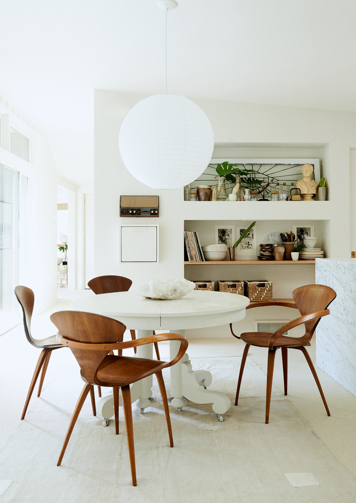 This is an example of a beach style dining room in Other with white walls and beige floor.