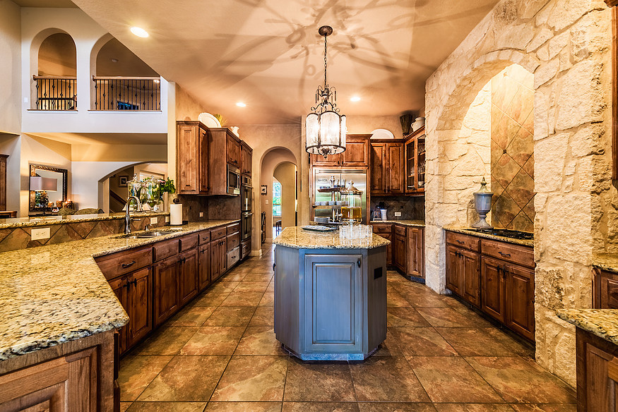 Design ideas for an expansive traditional kitchen in Austin with a double-bowl sink, raised-panel cabinets, distressed cabinets, granite benchtops, brown splashback, ceramic splashback, stainless steel appliances, ceramic floors and with island.