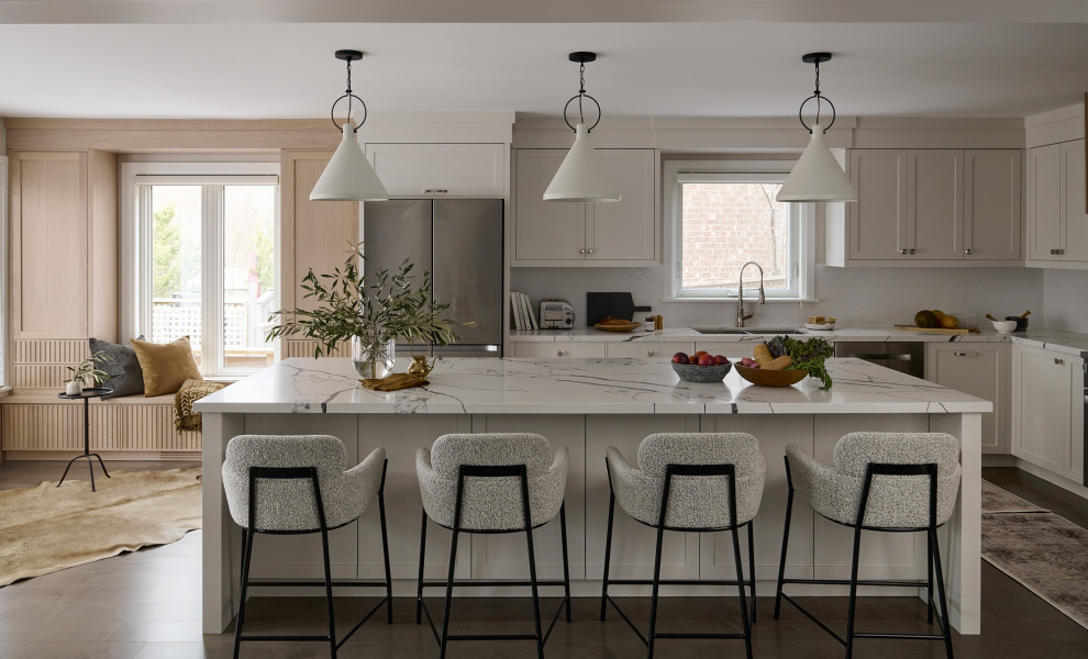 Kitchen - large transitional kitchen idea in Toronto with shaker cabinets, white cabinets, quartz countertops, white backsplash, ceramic backsplash, stainless steel appliances, an island and white countertops