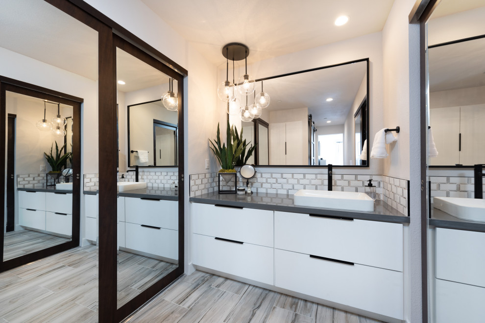 This is an example of a mid-sized beach style master bathroom in San Diego with flat-panel cabinets, white cabinets, white tile, subway tile, ceramic floors, engineered quartz benchtops, grey floor, grey benchtops, a single vanity, a built-in vanity, white walls and a vessel sink.