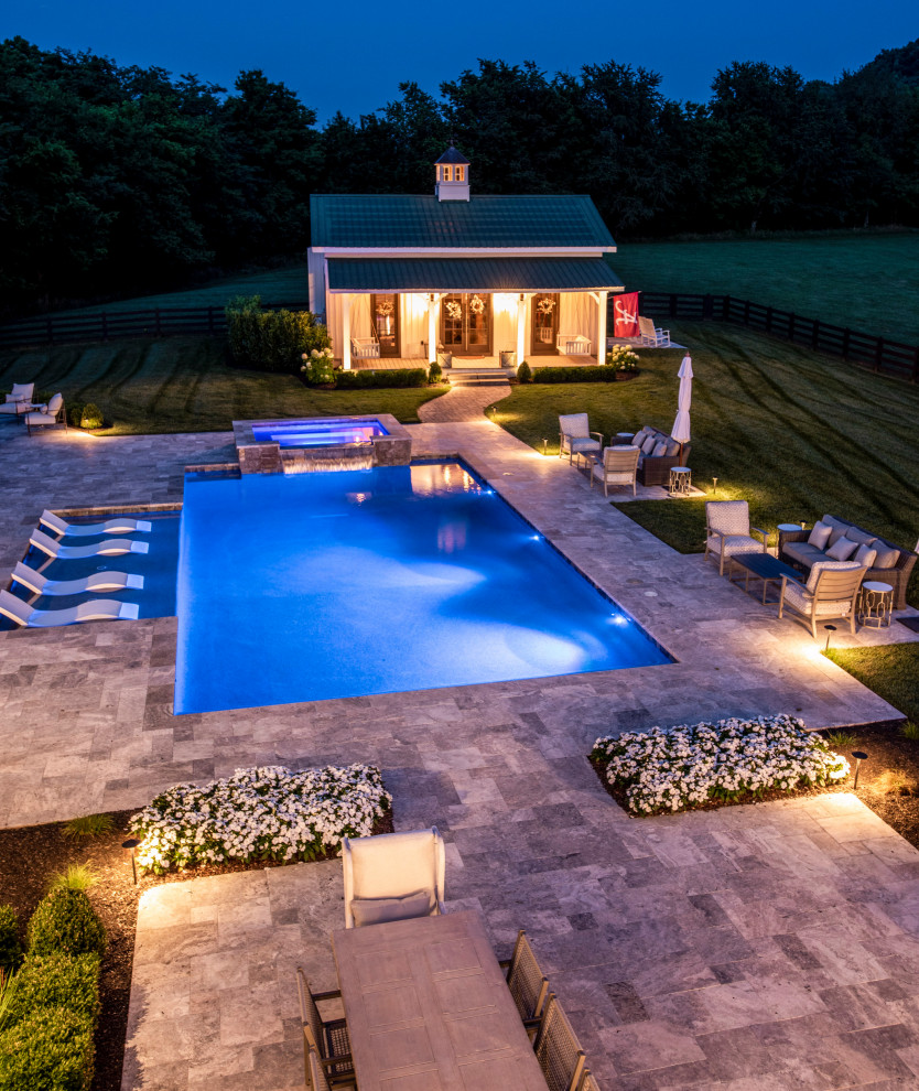 Foto de piscina campestre grande a medida en patio trasero con adoquines de piedra natural
