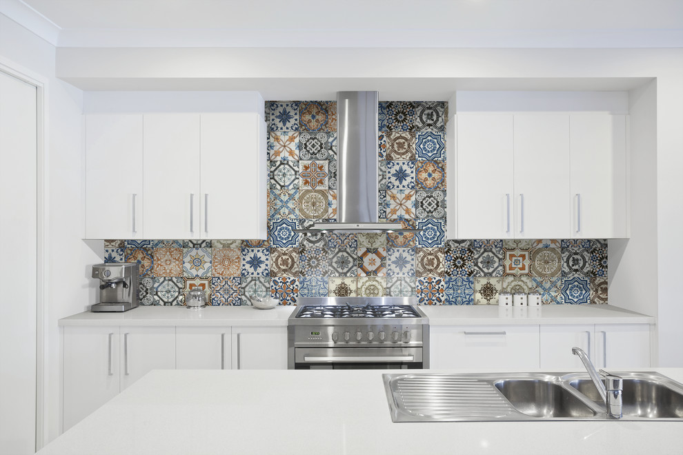Enclosed kitchen - enclosed kitchen idea in Denver with a double-bowl sink, white cabinets, quartz countertops, multicolored backsplash, ceramic backsplash and an island
