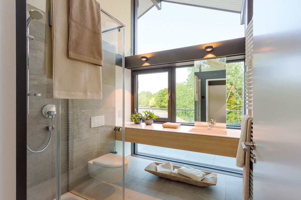 Kinderbad With flächenbündigen Schrankfronten, lila Schränken, freistehender Badewanne, bodengleicher Dusche, Wandtoilette, grauen Fliesen, Steinfliesen, weißer Wandfarbe, Einbauwaschbecken, Mineralwerkstoff-Waschtisch, grauem Boden, offener Dusche and weißer Waschtischplatte in London