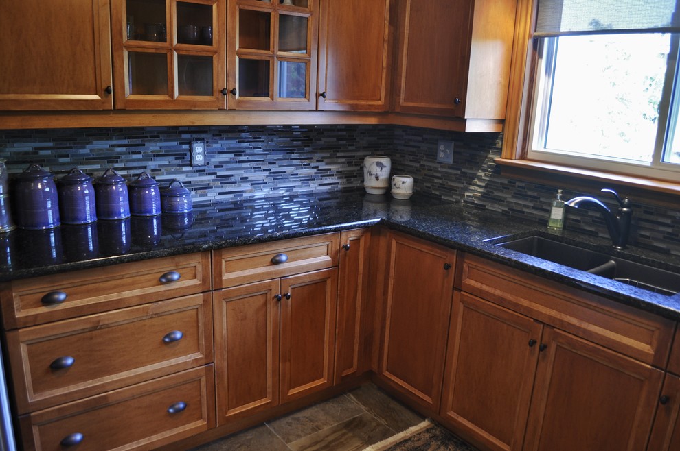 Inspiration for a mid-sized rustic l-shaped kitchen remodel in Toronto with an undermount sink, medium tone wood cabinets, granite countertops, blue backsplash, stainless steel appliances and no island