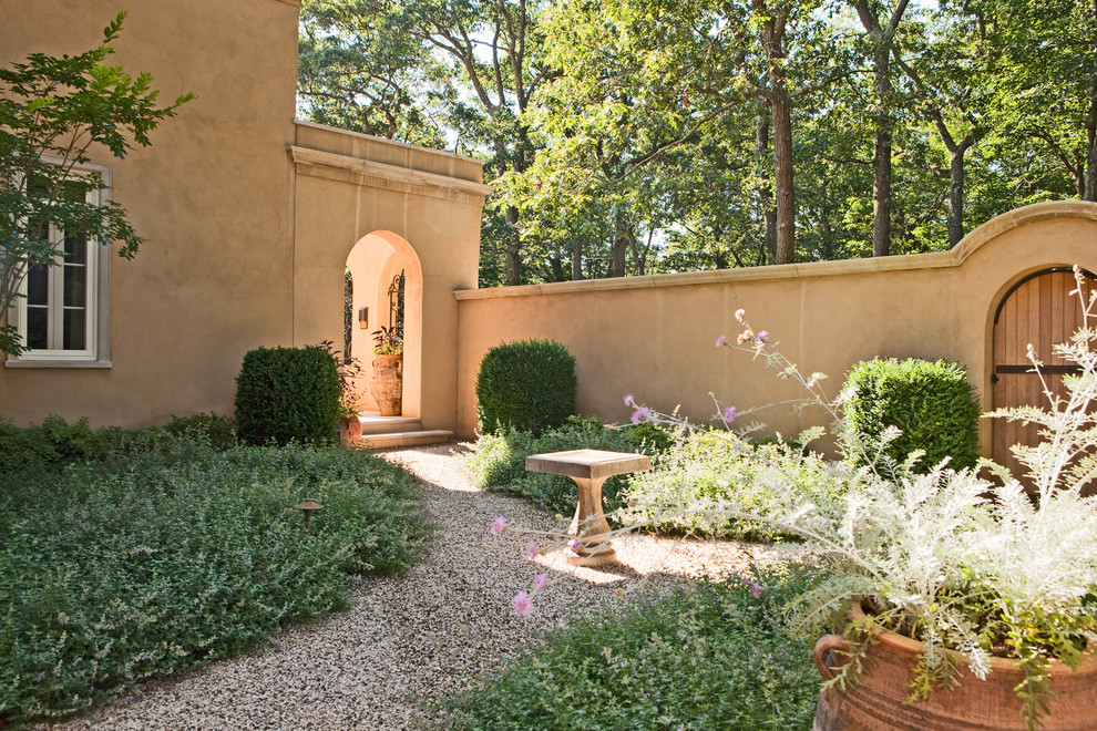 Inspiration for a mid-sized mediterranean courtyard patio in New York with a water feature, gravel and no cover.