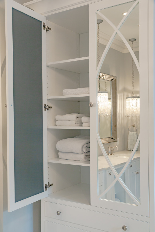 Пример оригинального дизайна: большая главная ванная комната в классическом стиле с фасадами с декоративным кантом, белыми фасадами, отдельно стоящей ванной, двойным душем, биде, серой плиткой, мраморной плиткой, серыми стенами, мраморным полом, врезной раковиной, столешницей из искусственного кварца, серым полом, душем с распашными дверями, белой столешницей, сиденьем для душа, тумбой под две раковины и встроенной тумбой