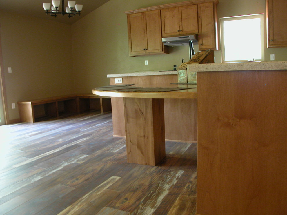 Example of a mountain style home design design with white cabinets, stainless steel appliances and an island