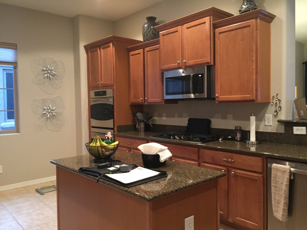 Kitchen - mid-sized transitional kitchen idea in Phoenix with recessed-panel cabinets, stainless steel appliances and an island