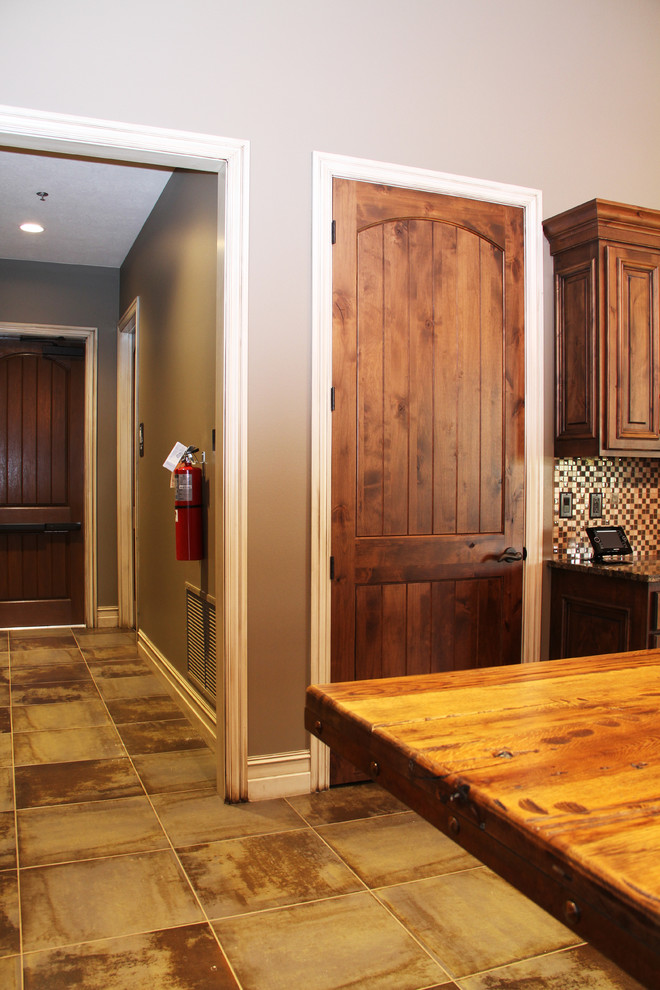Inspiration for a rustic ceramic tile kitchen remodel in Minneapolis with raised-panel cabinets, light wood cabinets, granite countertops, multicolored backsplash, glass tile backsplash, beige walls and an island