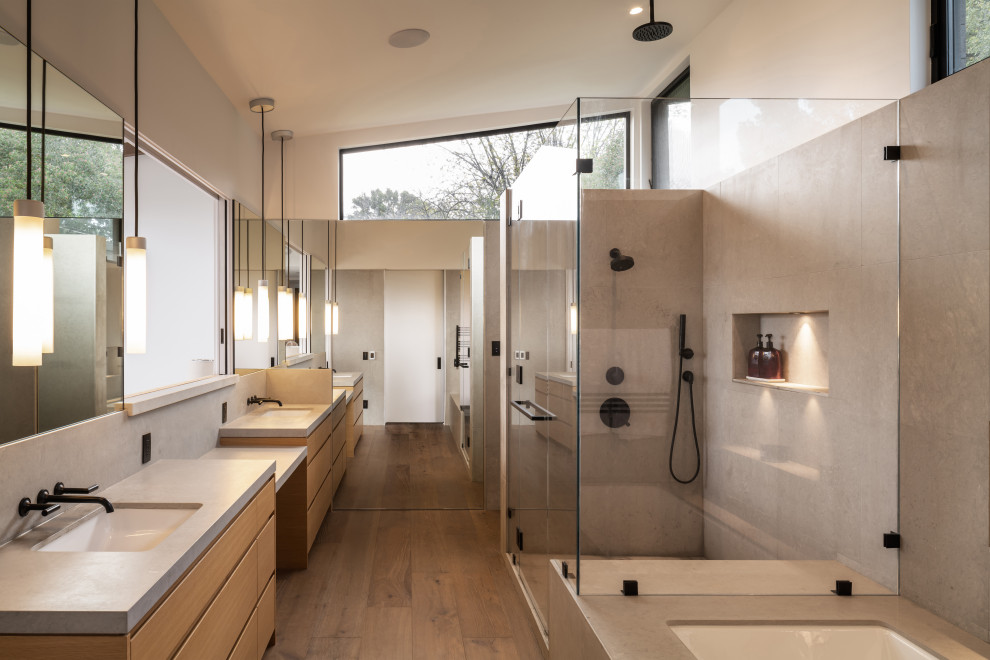 Inredning av ett modernt stort grå grått en-suite badrum, med släta luckor, skåp i mellenmörkt trä, ett undermonterat badkar, en öppen dusch, en vägghängd toalettstol, grå kakel, kakelplattor, vita väggar, mellanmörkt trägolv, ett undermonterad handfat, bänkskiva i kvartsit, brunt golv och dusch med gångjärnsdörr
