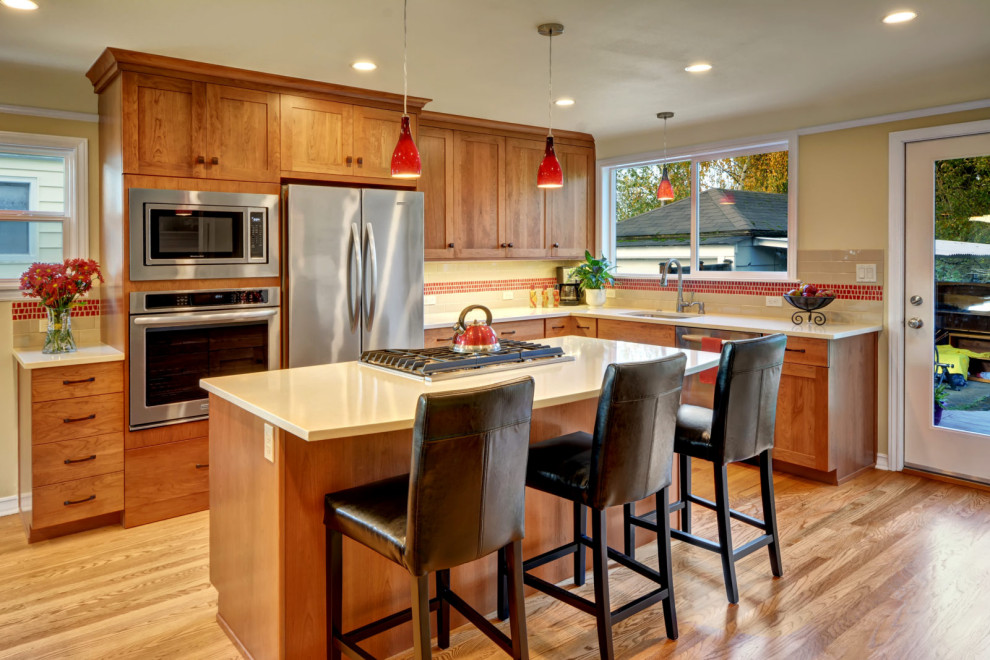 Eat-in kitchen - small l-shaped medium tone wood floor and brown floor eat-in kitchen idea in Seattle with an undermount sink, shaker cabinets, medium tone wood cabinets, red backsplash, mosaic tile backsplash, stainless steel appliances, an island and white countertops