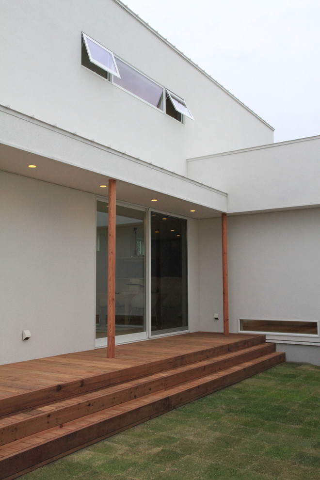 Cette photo montre un porche d'entrée de maison moderne avec une cuisine d'été, une terrasse en bois et une extension de toiture.