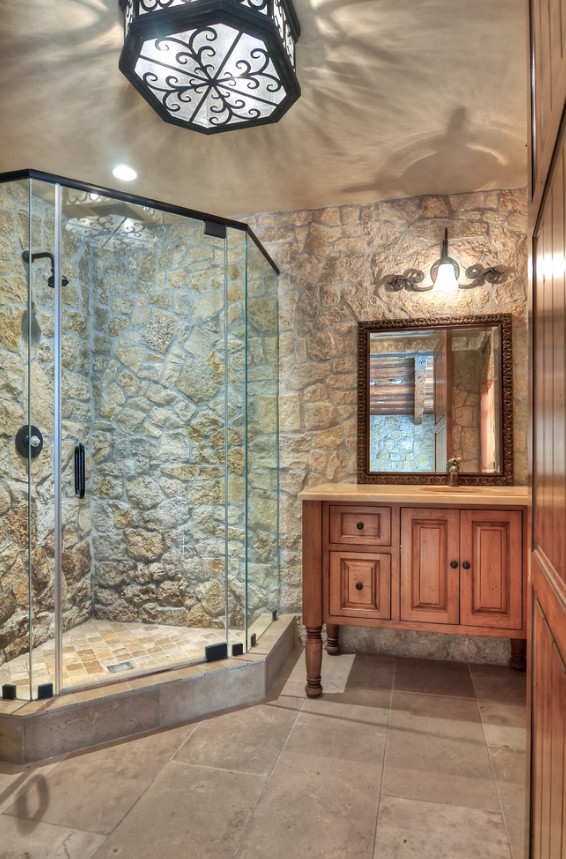 Large mediterranean master bathroom in Los Angeles with furniture-like cabinets, dark wood cabinets, a drop-in tub, a corner shower, gray tile, ceramic tile, beige walls, ceramic floors, an undermount sink, granite benchtops, grey floor and an open shower.