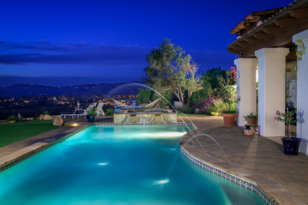 This is an example of a large mediterranean backyard rectangular lap pool in San Diego with with a pool and concrete pavers.