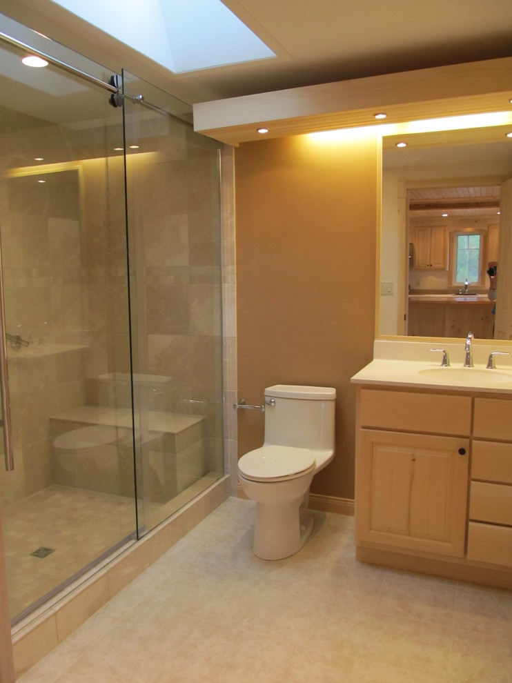 Photo of a small country master bathroom in Other with beige tile, stone tile, beige walls, an integrated sink, raised-panel cabinets, beige cabinets, an alcove shower, a one-piece toilet, limestone floors, laminate benchtops, beige floor and a sliding shower screen.