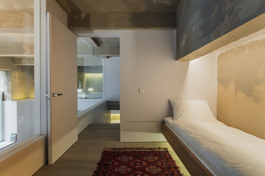 На фото: маленькая гостевая спальня (комната для гостей) в стиле лофт с бежевыми стенами, деревянным полом и бежевым полом для на участке и в саду